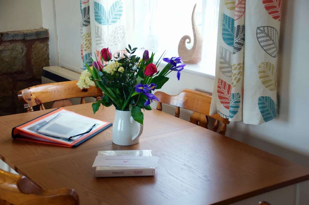 Coshes garden cottage holiday let with dining table and vase of flowers